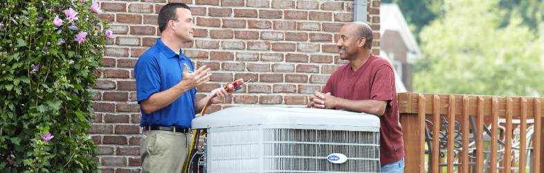Carrier Tech Talking To Homeowner Next To Heat Pump