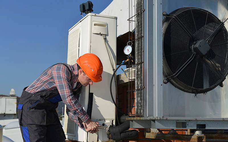 Hvac Tech Working On Commercial System Hvac Tech Working On Commercial System